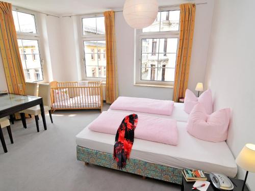 赖兴巴伊姆福格特兰米勒斯阿尔特巴克斯图膳食公寓酒店的一间卧室配有一张带粉色枕头的床和一张书桌