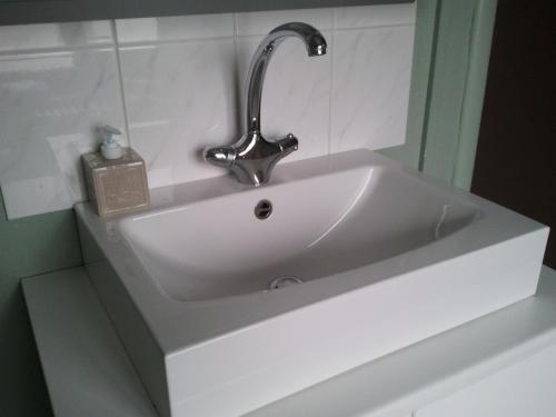 奥斯坦德Hotel Duinekeuntje的浴室内设有一个白色水槽和水龙头