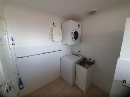 朱里恩湾海洋沙滩木屋18的小型浴室设有洗衣机和水槽。