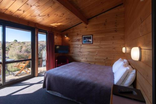 华卡帕帕村斯格特尔阿尔卑斯山度假村的一间卧室设有一张床和一个大窗户