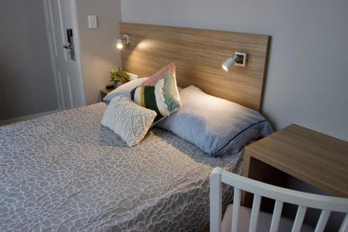 悉尼Carnarvon Lodge Kirribilli, Sydney的一间卧室配有一张带木制床头板和枕头的床。