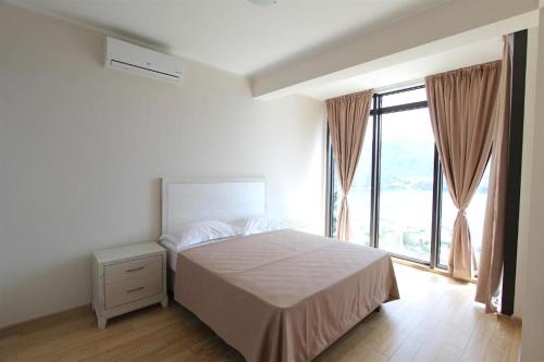 布德瓦Apartments Aqua的一间卧室设有一张床和一个大窗户