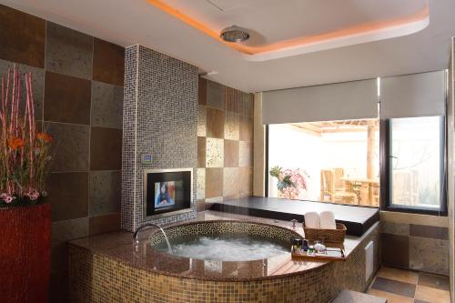 高雄香堤时尚旅馆的一间带大浴缸及窗户的浴室