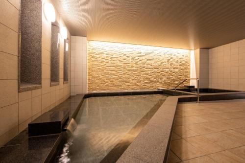 大阪唐草鼎盛酒店新大阪的游泳池,浴室设有砖墙