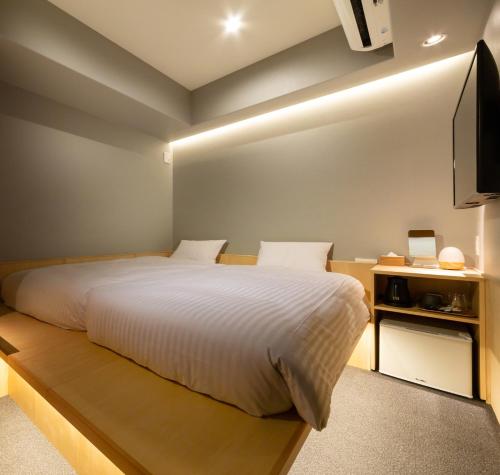 京都HOTEL AMANEK Kyoto Kawaramachi Gojo的一间卧室配有一张大床和电视