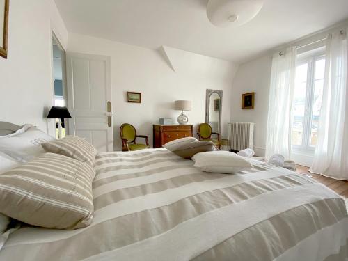 勒谢奈Les Chambres de LOUIS的白色卧室配有带枕头的大床