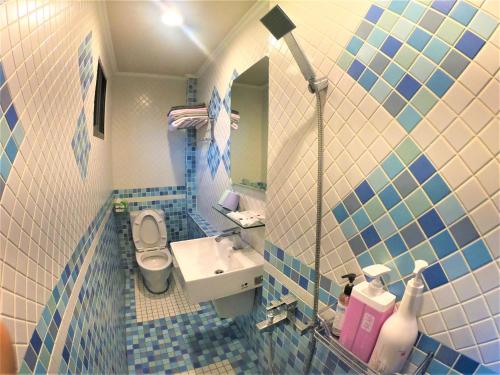 小琉球岛岛主民宿的蓝色和白色的浴室设有水槽和卫生间
