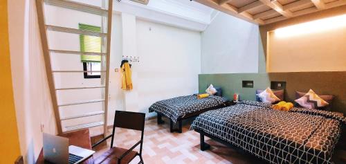 玛琅马朗玛多尔多姆旅舍的一间卧室设有两张床和窗户。