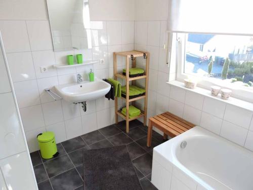 温特贝格Ferienhaus - Haus Winterberg的浴室配有盥洗盆、卫生间和浴缸。