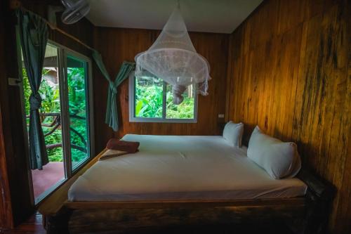 皮皮岛皮皮岛余晖湾度假酒店的一间卧室设有一张大床和窗户