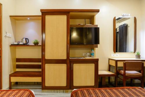 孟买Hotel Ameya的一间客房内配有床和电视的房间