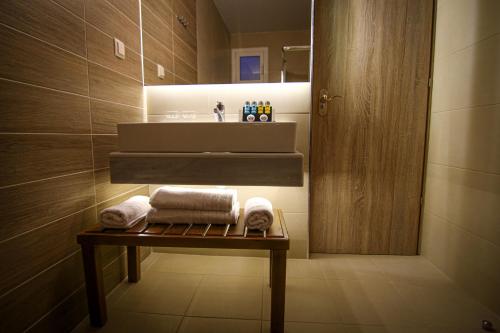 塞萨洛尼基La Place Suites - La Place De La Gare的一间带水槽和桌子毛巾的浴室