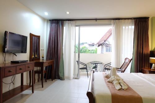 卡塔海滩Phuket Racha Kata Homestay的酒店客房设有床、电视和桌子。