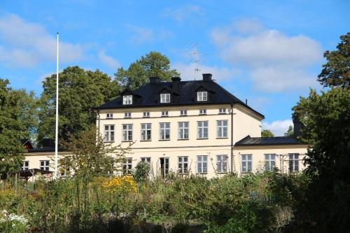 斯德哥尔摩Riddersviks Herrgård的黑色屋顶的白色大建筑