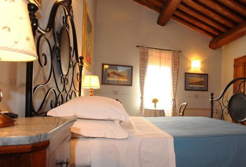 Solomeo博尔戈乡村度假酒店的一间卧室配有一张带锻铁床头板的床