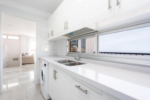 法纳贝海滩Home2Book Stunning Sea Views Adeje, Wifi & Pool的白色的厨房设有水槽和窗户
