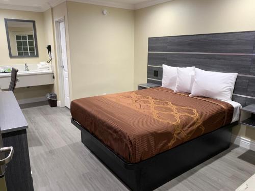 安纳海姆阿纳海姆太平洋酒店的一间卧室配有一张床,浴室设有水槽