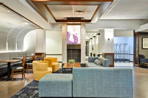 坦帕Hyatt Place Tampa Airport/Westshore的大堂配有沙发和桌椅