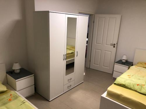 鲁尔河畔米尔海姆4realax的卧室内的白色橱柜,配有两张床
