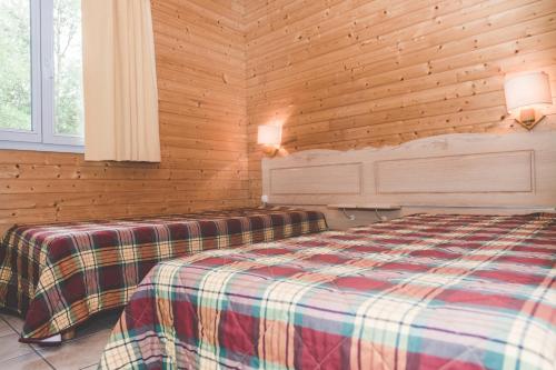 蒙科坦特Terres de France - Natura Resort Pescalis的卧室配有木墙内的一张床