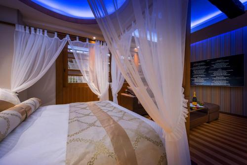 滨松HOTEL Dior7的一间卧室配有白色窗帘的床