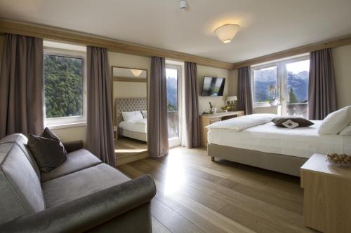 摩德纳迪-坎皮格里奥洛伦泽蒂酒店的酒店客房,设有两张床和一张沙发