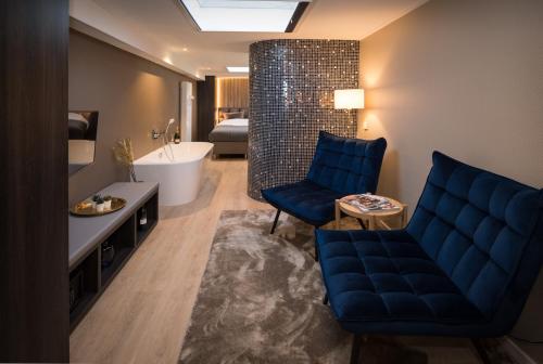 亨厄洛B&B Centrum Hengelo的浴室配有蓝色的沙发和浴缸。