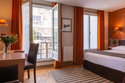 巴黎沃尔尼歌剧酒店的配有一张床、一张书桌和一扇窗户的酒店客房