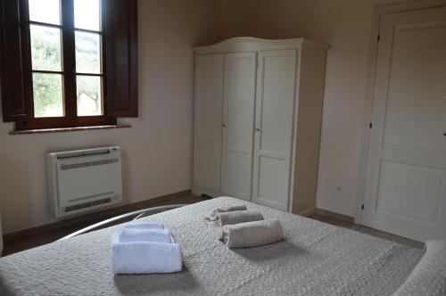 卡斯塔涅托卡尔杜奇Le Bozze "Casa Olivo"con piscina, WI-FI的一间卧室配有带毛巾的床