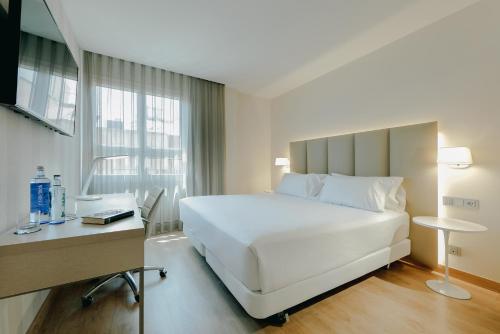 穆尔西亚Hesperia Murcia Centro的卧室配有一张白色大床和一张书桌