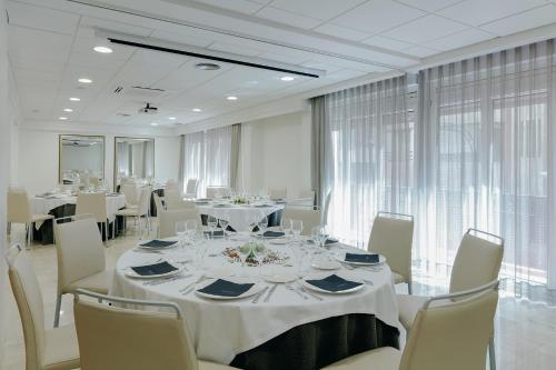 穆尔西亚Hesperia Murcia Centro的用餐室配有白色的桌子和白色的椅子