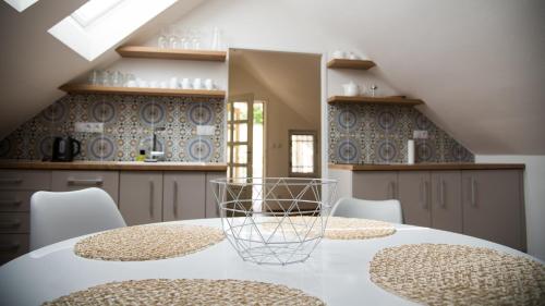 米库洛夫Apartmán Veritas的一间带白色桌椅的厨房和一间带蓝色瓷砖的厨房