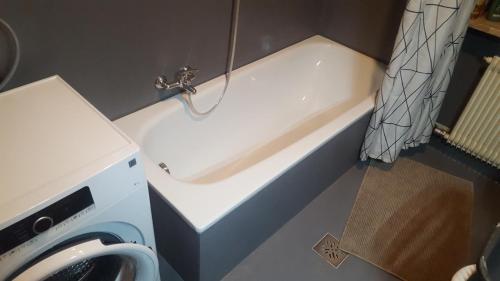拉纳SonnenApartment的带浴缸的浴室和洗衣机。