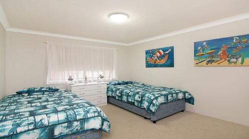 金斯克里福Kingscliff Waters Apartment 5的一间卧室设有两张床和窗户。