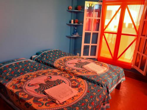 蓬蒂切里Holi-Wood Guesthouse的带窗户的客房内设有两张单人床。
