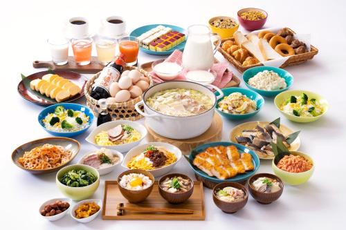 东广岛市东广岛船舶酒店的餐桌,餐桌上满是各种碗和盘子的食物