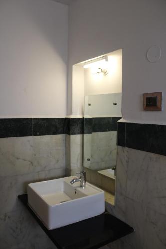 迈索尔Kaveri Hotel Bed & Breakfast的浴室设有白色水槽和镜子