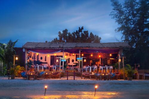 高龙撒冷岛Bamboo Jam的一间晚上在海滩上带桌椅的餐厅
