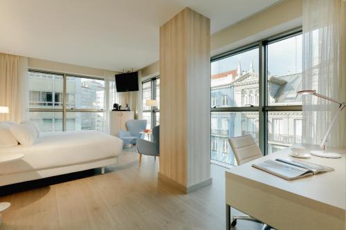 拉科鲁尼亚Hesperia A Coruña Centro的酒店客房配有一张床、一张书桌