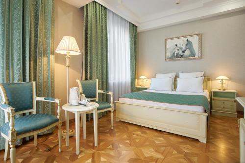 别尔哥罗德别尔哥罗德酒店的酒店客房,配有一张床和两把椅子
