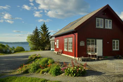 TautraKlostergården Bed & Breakfast的前面有长凳和鲜花的红色谷仓