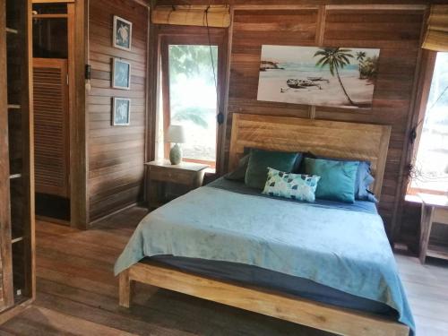 Punta Bajo RicoSonny Island Resort的卧室配有一张床铺,位于带木墙的房间内