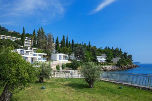 米利尼Maistra Select Mlini Villas and Apartments的水边山丘上的一群房子