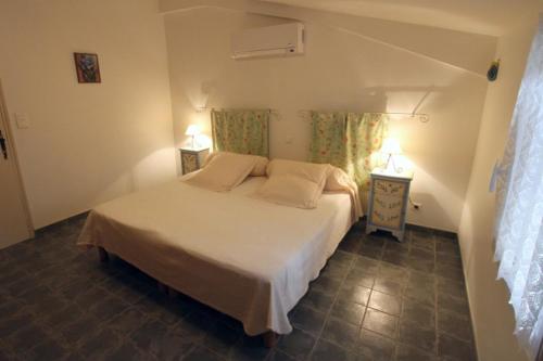 MollégèsLes Glycines的卧室配有白色的床和两盏灯。