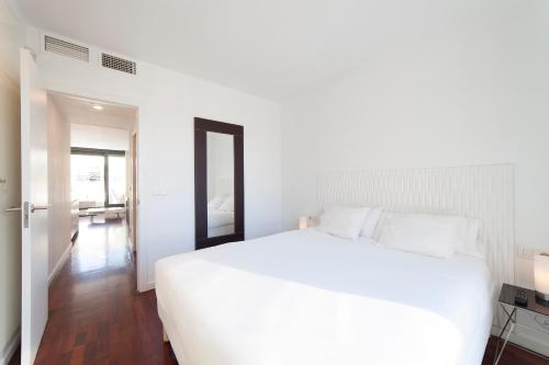 瓦伦西亚Ático Valencia Centro的卧室配有一张白色大床和镜子