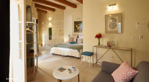 维多利亚Provicario的客房设有床、沙发和桌子。