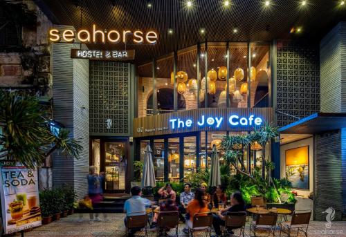 岘港Seahorse Han Market Da Nang Hostel by Haviland的一群坐在餐厅前桌旁的人
