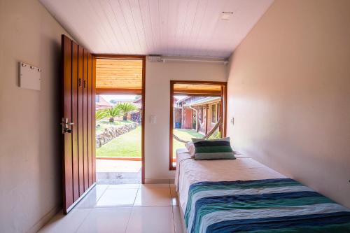 博尼图帕萨达姆特波尼特酒店的一间卧室设有一张床,一扇门通往庭院