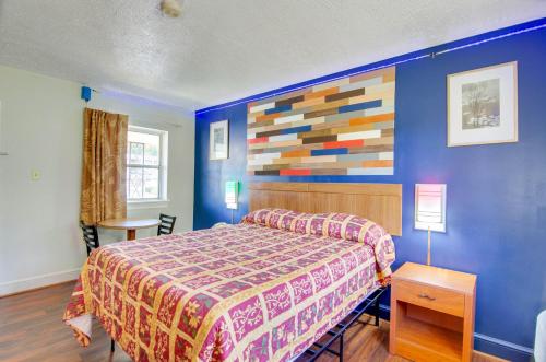 CollinsvilleScottish Inns Collinsville - Martinsville的一间卧室设有一张床和色彩缤纷的墙壁