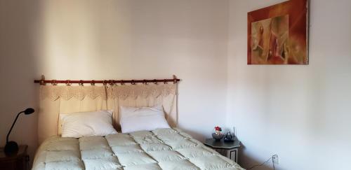萨尔塔La casa del Paseo的一间卧室配有一张带白色床单和绘画的床。